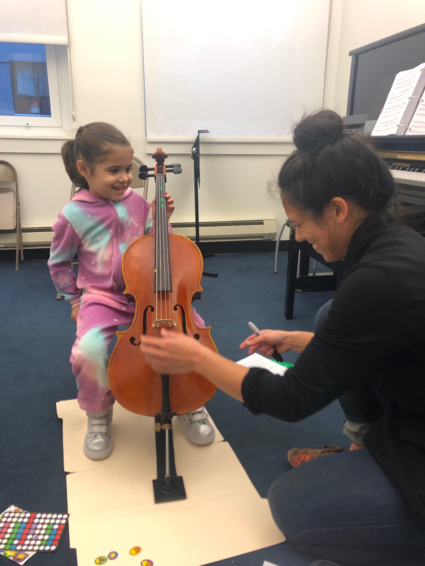 Young student smiling while holding a fractional cello